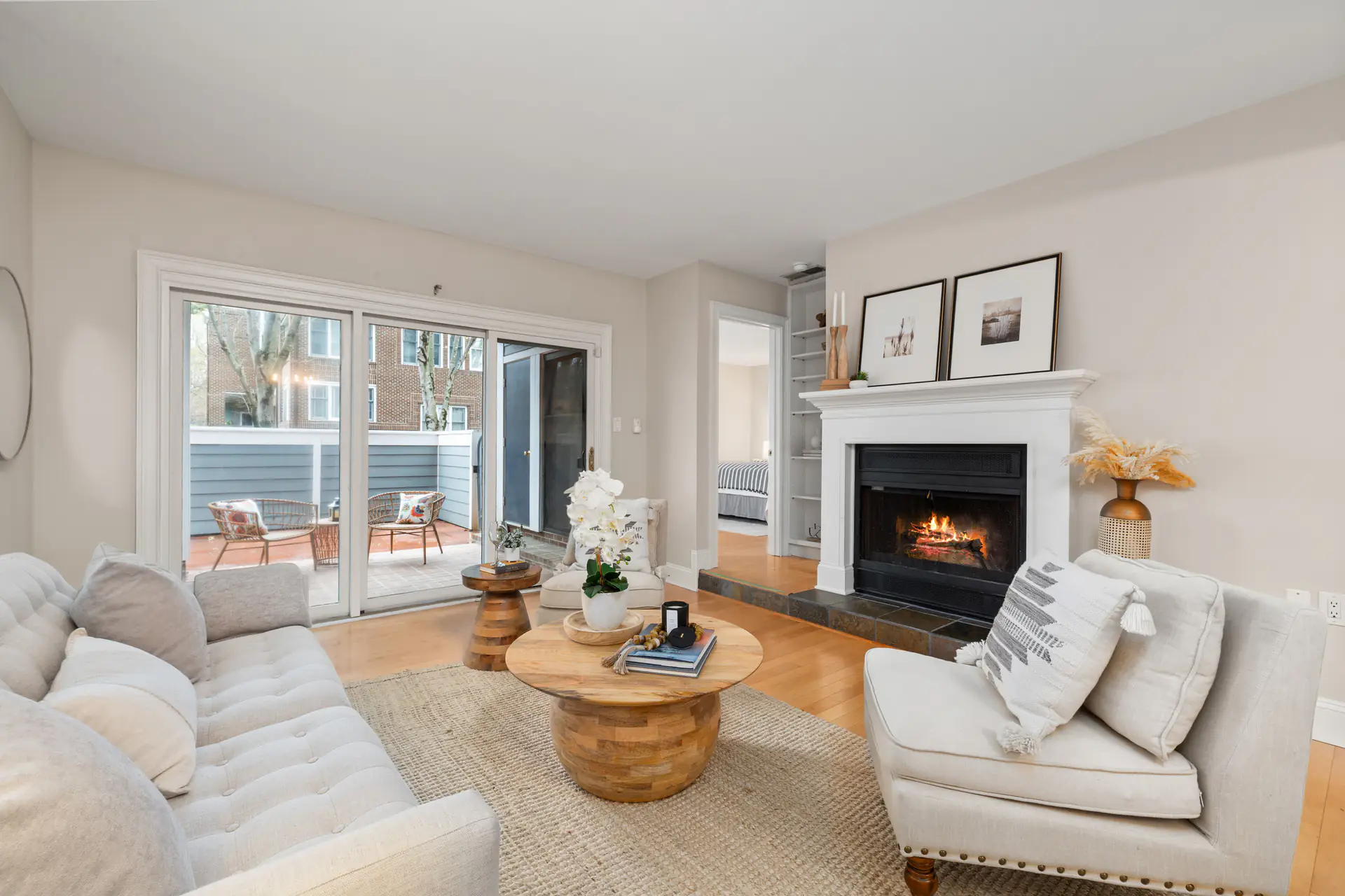 A bright living room with a fireplace and a door out to the deck