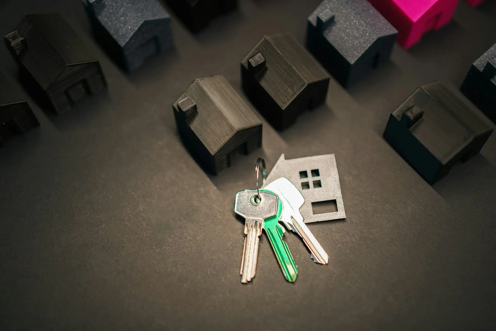 A set of house keys beside a row of small model houses
