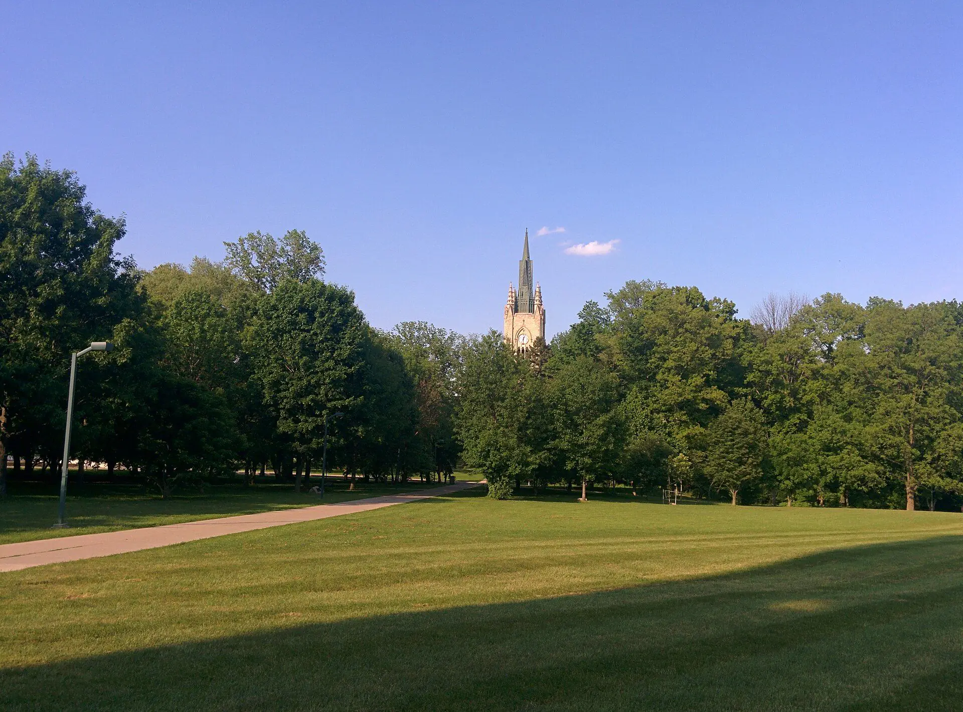 The University College tower of Western University rising above the trees of the Medway green