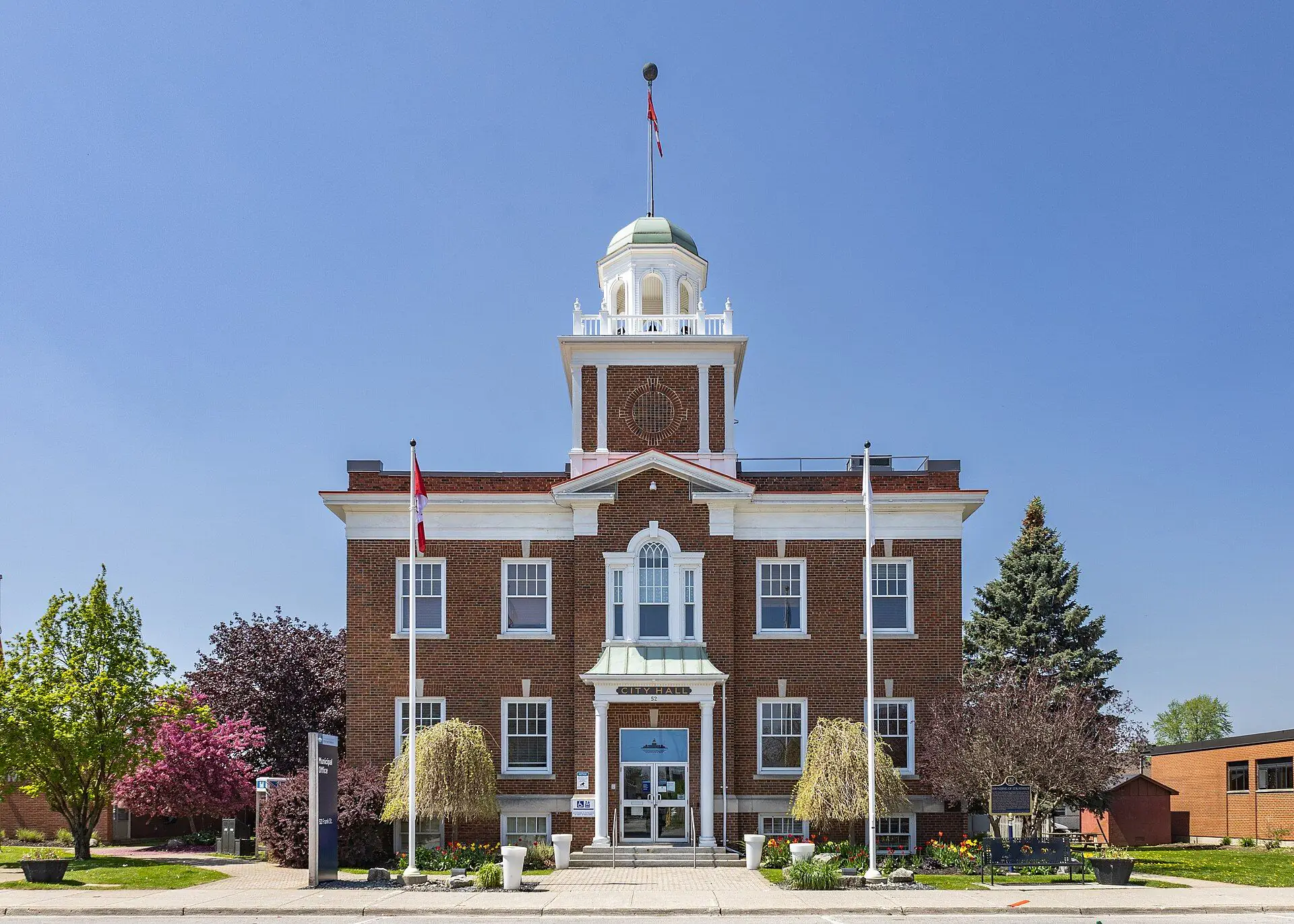 Strathroy Town Hall, red brick with a white cupola, under a clear sky