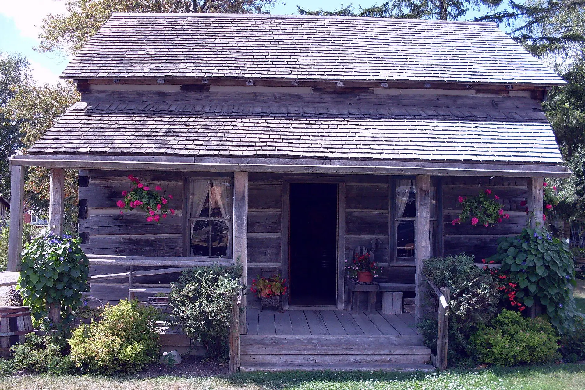 The log Donnelly schoolhouse with geraniums on its front porch at the heritage museum in Lucan