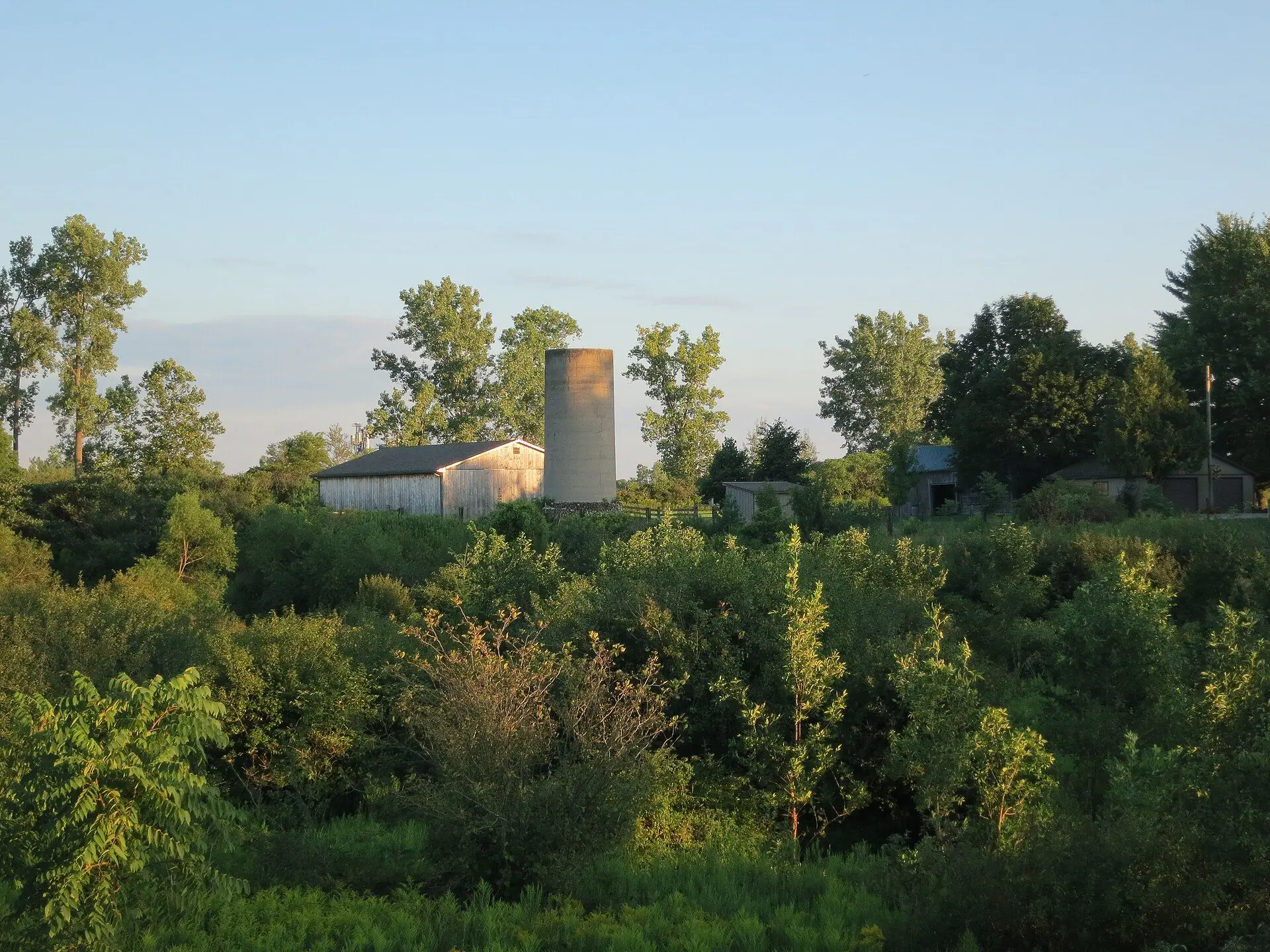 A red barn and farmhouse under a soft morning sky near Komoka, Middlesex County