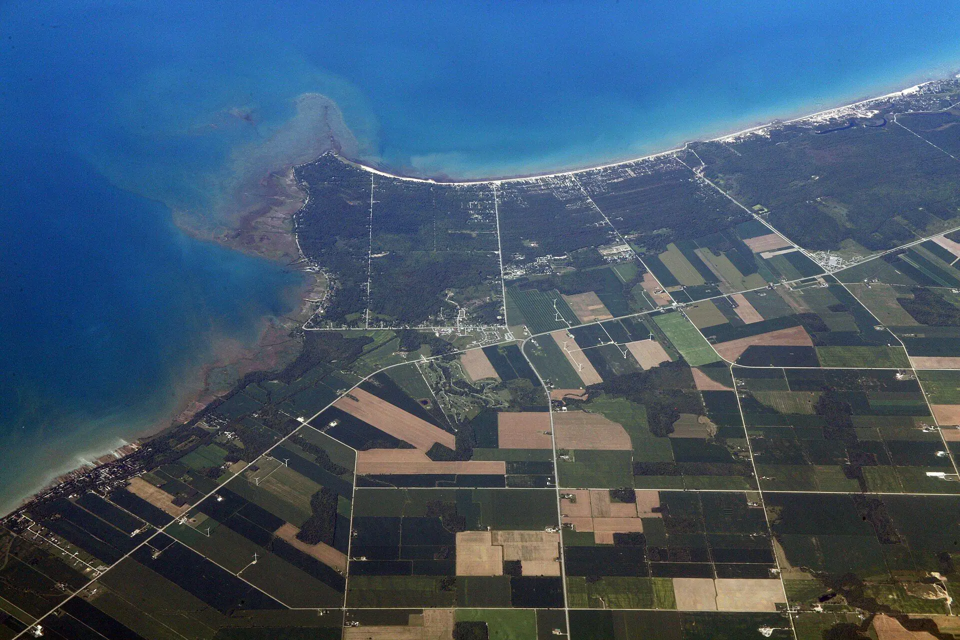 Aerial view of Kettle Point reaching into Lake Huron, with the wooded shoreline and farm fields inland