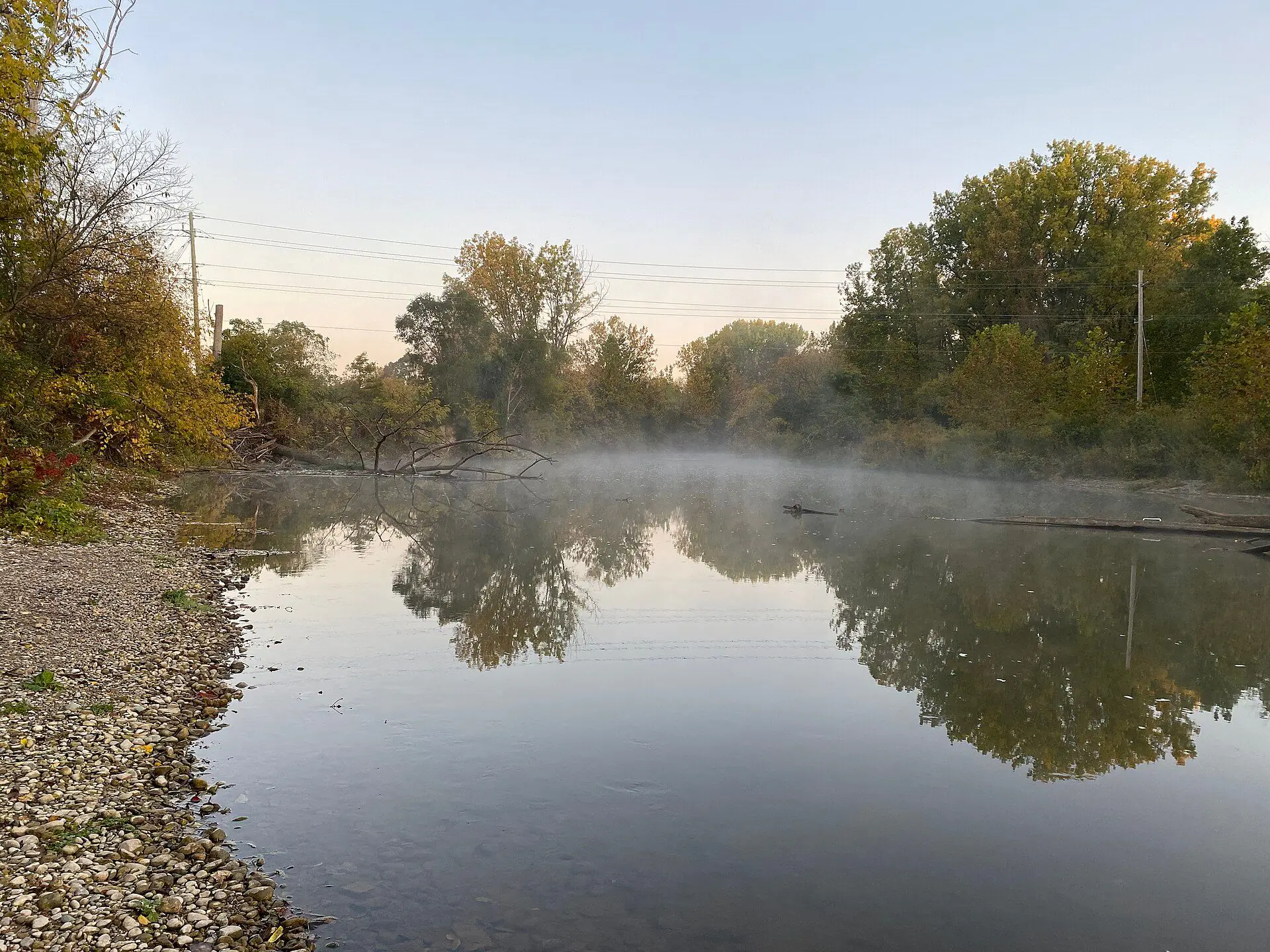 Morning mist on the North Thames River between autumn trees in Stoneybrook