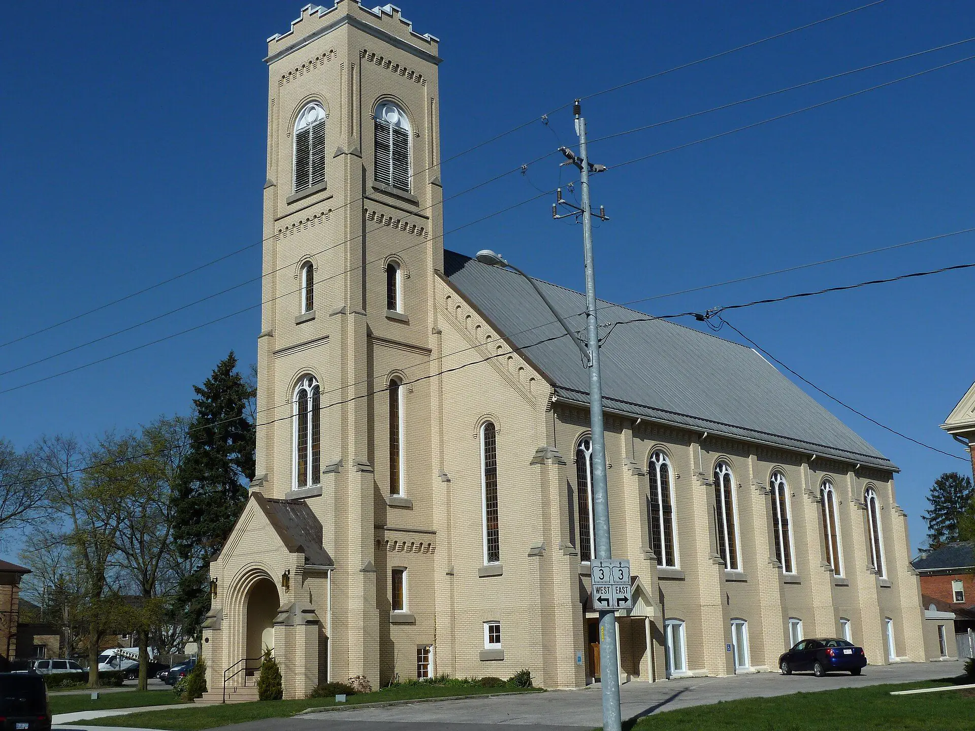 The buff-brick Aylmer Baptist Church and its tall bell tower