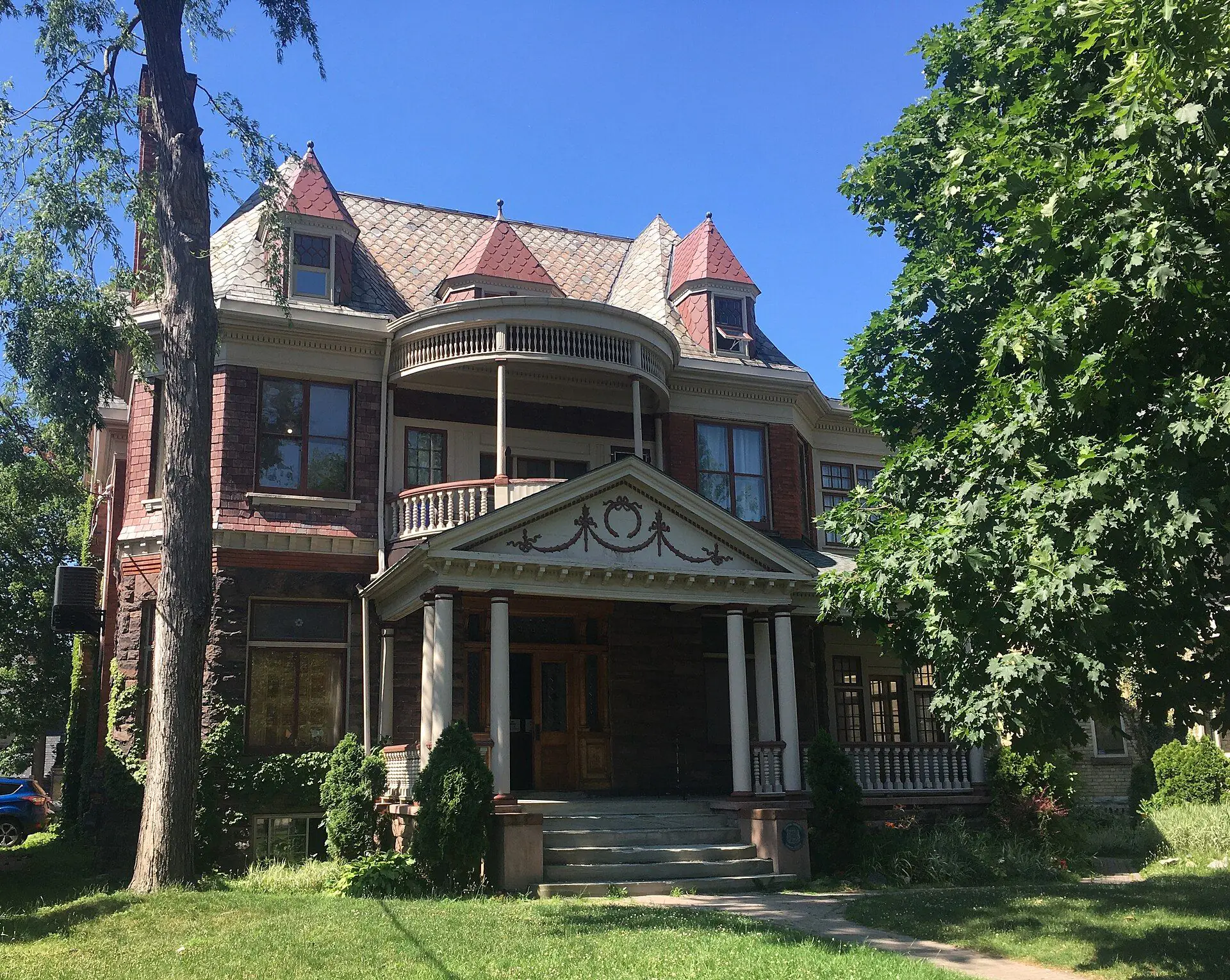 A red-brick Queen Anne house with a round balcony and slate turrets on Princess Avenue in Woodfield