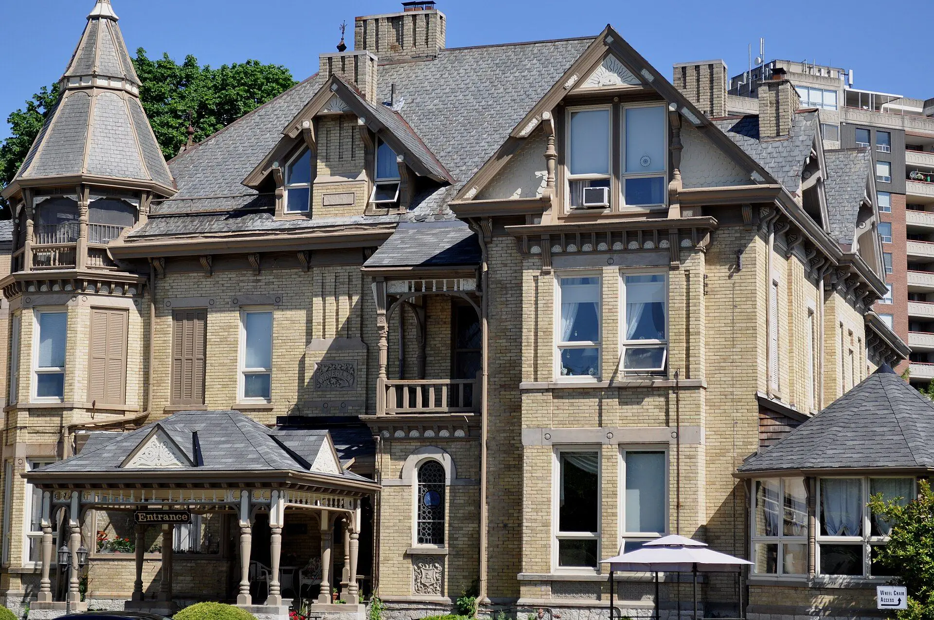 A Second Empire buff-brick mansion with a turret and slate roof on Grand Avenue